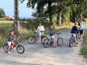 a group of children riding bikes on a road at Gîte de charme avec piscine, Wi-Fi et animaux acceptés - FR-1-496-26 in Saint-Germain-Laval