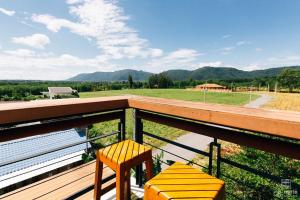 a balcony with two chairs and a view of a field at Sethachan Poolvilla Khaoyai in Ban Rai Khlong Sai +31 photos