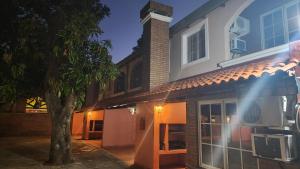 een huis met een boom ervoor bij Posada del Sol in Ituzaingó