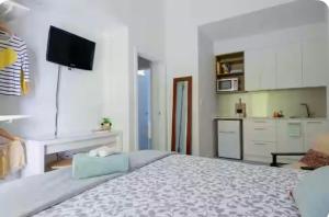 une chambre avec un grand lit et une cuisine dans l'établissement Fremantle Harbour Studio, à Fremantle 3 autres photos