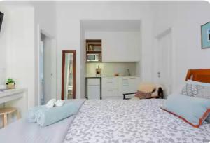 - une chambre blanche avec un grand lit et une cuisine dans l'établissement Fremantle Harbour Studio, à Fremantle