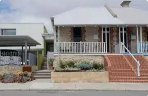 une maison en briques avec une terrasse couverte blanche et des escaliers dans l'établissement Fremantle Harbour Studio, à Fremantle