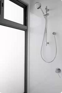 La salle de bains est pourvue d'une douche et d'une fenêtre en verre. dans l'établissement Fremantle Harbour Studio, à Fremantle