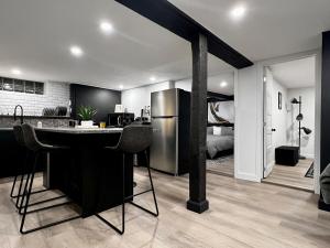 a kitchen with a bar with a refrigerator and a bedroom at Edinburgh in Drummondville