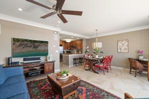 een woonkamer met een blauwe bank en een tv bij Lahaina Shores PH3 in Wainee