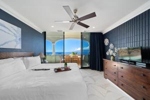 een slaapkamer met een groot bed met een plafondventilator bij Lahaina Shores PH3 in Wainee +45 foto's
