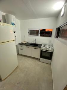 una cucina con frigorifero, piano cottura e lavandino di Quintas Baradero a Baradero