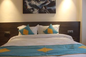 een slaapkamer met een bed met blauwe en gele kussens bij Hotel Crown Plaza in Kathmandu +17 foto's