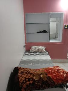 een bed in een kamer met een raam bij Surya Vinayak Homestay in Ghātsīla +5 foto's