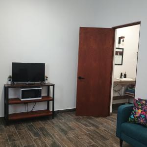 a living room with a television on a table and a door at Casa Loto D in Chelem