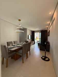 ein Esszimmer mit einem Tisch, Stühlen und einer Kamera in der Unterkunft Apartamento 03 quartos Pajucara mcz in Maceió