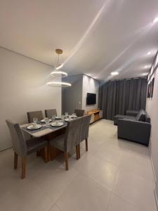 a dining room with a table and chairs at Apartamento à poucos metros da praia de Pajuçara e ponta verde in Maceió