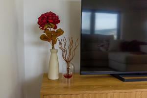 a vase with a red flower in it on a table at Cherry Douro Hill in Resende +22 photos
