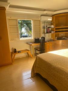 a bedroom with a bed and a desk and a window at Med House in Guaíra