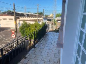 a balcony with a fence and a sidewalk at Med House in Guaíra