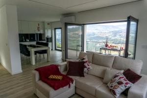 a living room with a white couch and a kitchen at Cherry Douro Hill in Resende