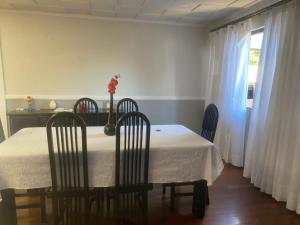 a dining room with a table and chairs and a window at Med House in Guaíra