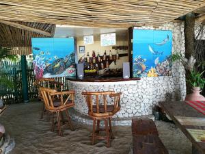 a bar with two chairs and a counter with bottles of wine at Ravenala Beach Bungalows in Moalboal