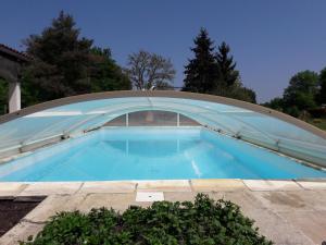a large swimming pool with a curved roof at Studio à la campagne avec piscine partagée et jardin - FR-1-489-230 in Vendat