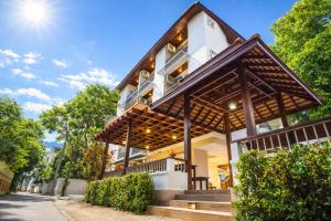 a white building with a gambrel roof at Rendezvous Classic House in Chiang Mai