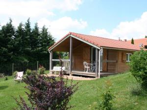eine kleine Holzhütte mit einer Veranda in einem Hof in der Unterkunft Chalets avec Animaux, Terrasse et Parking - FR-1-489-323 in Échassières + 1 Foto