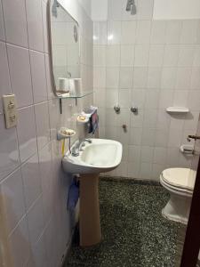 a bathroom with a sink and a toilet at Montecarlo in Mar de Ajó +2 photos