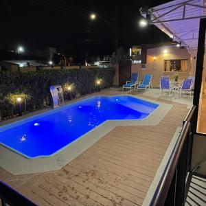 una grande piscina blu su una terrazza di notte di Hotel La Roza e Restaurante Grill a Penha