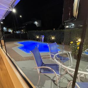 un patio con sedie e una piscina di notte di Hotel La Roza e Restaurante Grill a Penha