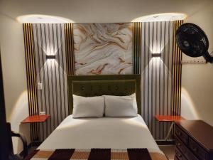 a bedroom with a bed with a wooden head board at Hotel 50 Suites in Caldas