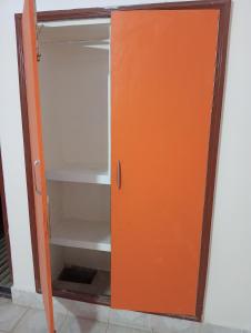 an open refrigerator with an orange door at SuryaVinayak Home Stay - 10min walk from Railway station in Ghātsīla