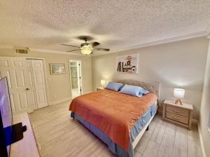 Un dormitorio con una cama y un ventilador de techo. en Grand Laguna 3BR Penthouse Near Disney Parks, en Kissimmee