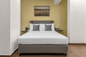 une chambre avec un grand lit avec des draps blancs dans l'établissement Wandr Hotel Richmond Road, à Bangalore 28 autres photos