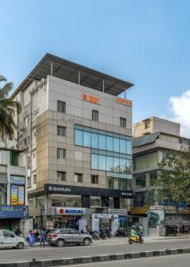 un edificio alto con macchine parcheggiate di fronte di Wandr Hotel Richmond Road a Bangalore