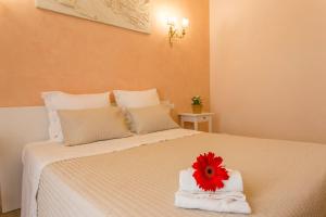 um quarto com uma cama com toalhas e uma flor vermelha em Amedeo Apartment em Roma