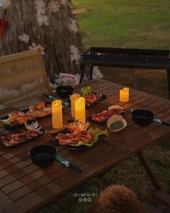 einen Picknicktisch mit Essen und Kerzen darauf in der Unterkunft LIA Retreat & Coffee 