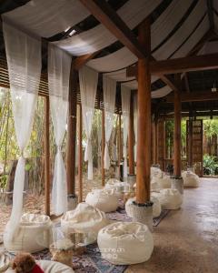 Eine Reihe weißer Betten in einem Zimmer mit Vorhängen in der Unterkunft LIA Retreat & Coffee  + 24 Fotos