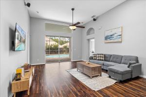 un soggiorno con un divano e un tavolo di NEW - Poolside Oasis Heated POOL Home - 2000 SF a Zephyrhills
