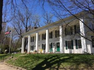 a white house with a flag in front of it at Historic Rider's Hostelry in Painesville