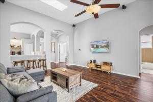 un soggiorno con un divano e un ventilatore a soffitto di NEW - Poolside Oasis Heated POOL Home - 2000 SF a Zephyrhills