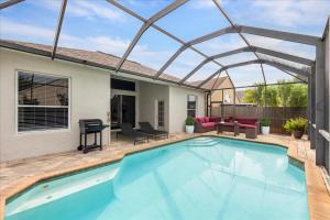 una piscina con pergolato accanto a una casa di NEW - Poolside Oasis Heated POOL Home - 2000 SF a Zephyrhills