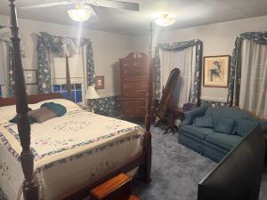 ein Schlafzimmer mit einem Bett und einer Couch in der Unterkunft Historic Rider's Inn in Mentor