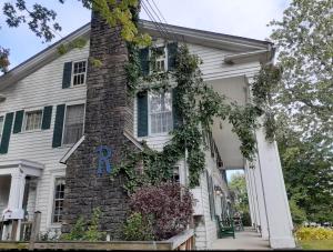 ein altes Backsteinhaus mit Efeu darauf in der Unterkunft Historic Rider's Inn in Mentor