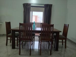 een eettafel en stoelen met een raam bij Amaira Studio living - Coimbatore in Coimbatore