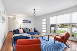een woonkamer met een blauwe bank en rode stoelen bij Forest Glen Silver Spring Gem - Parking in Silver Spring