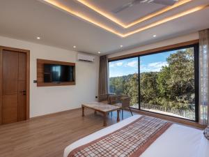 una camera da letto con un letto e una grande finestra di Moustache Select Nainital a Nainital Altre 38 foto