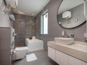 bagno con lavabo, servizi igienici e specchio di Moustache Select Nainital a Nainital