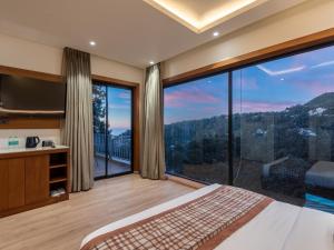 una camera da letto con una grande finestra con vista sulle montagne di Moustache Select Nainital a Nainital