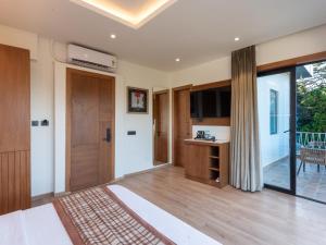 una camera da letto con un letto grande e una porta scorrevole in vetro di Moustache Select Nainital a Nainital