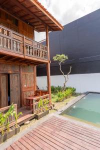 ein Haus mit einem Balkon und einem Pool in der Unterkunft Kalyana Gangga in Krambitan