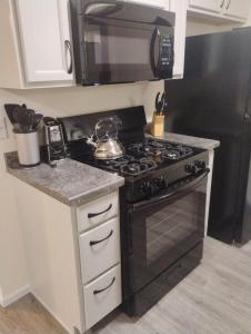 a kitchen with a stove and a microwave at 5 blocks from the hospital! in Bismarck +13 photos